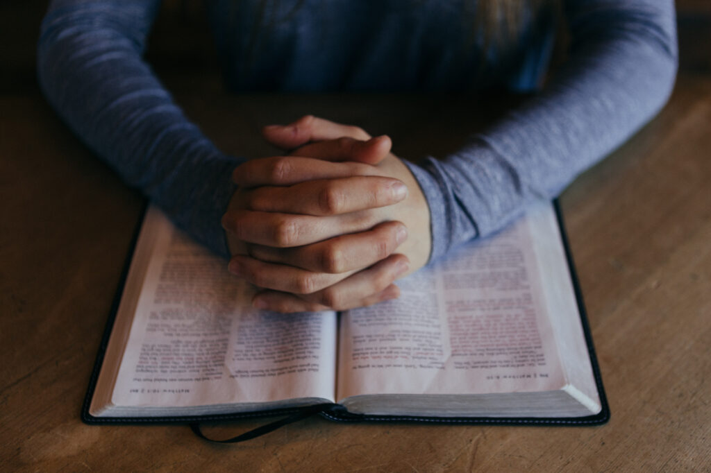 Gefaltete Hände auf der Bibel